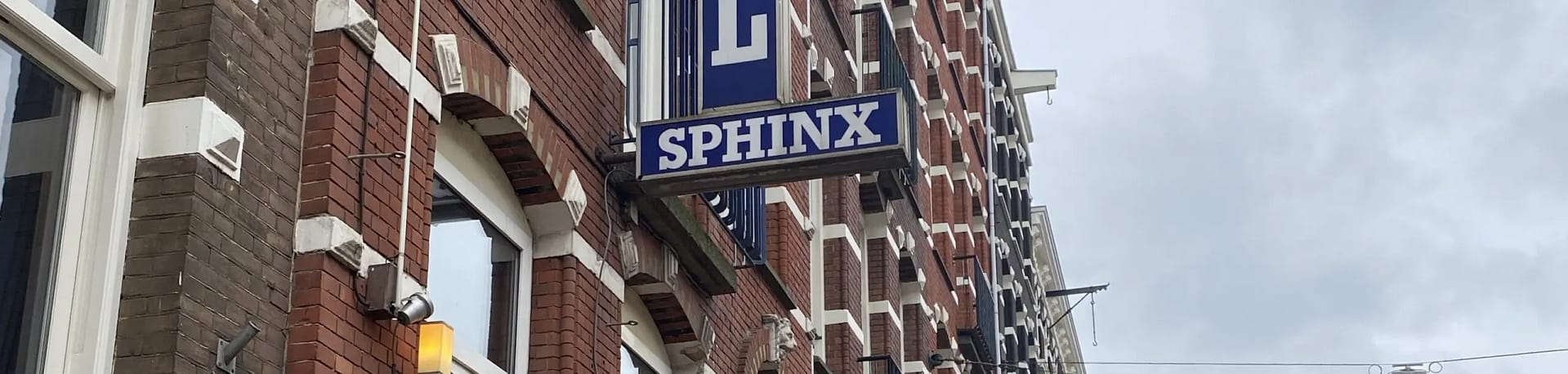 "Exterior sign of Sphinx Hotel in Amsterdam with red brick building"