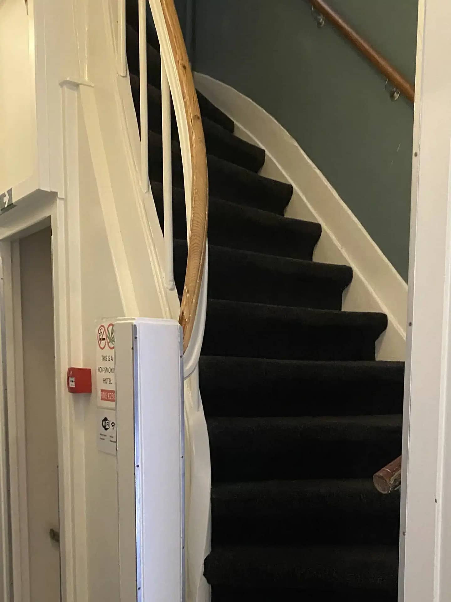 Steep staircase with black carpet and wooden handrail at Budget Hotel Sphinx Amsterdam.
